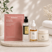 Biodance skincare products including a mask, essence, cream, and oil on a marble tray with a neutral background.